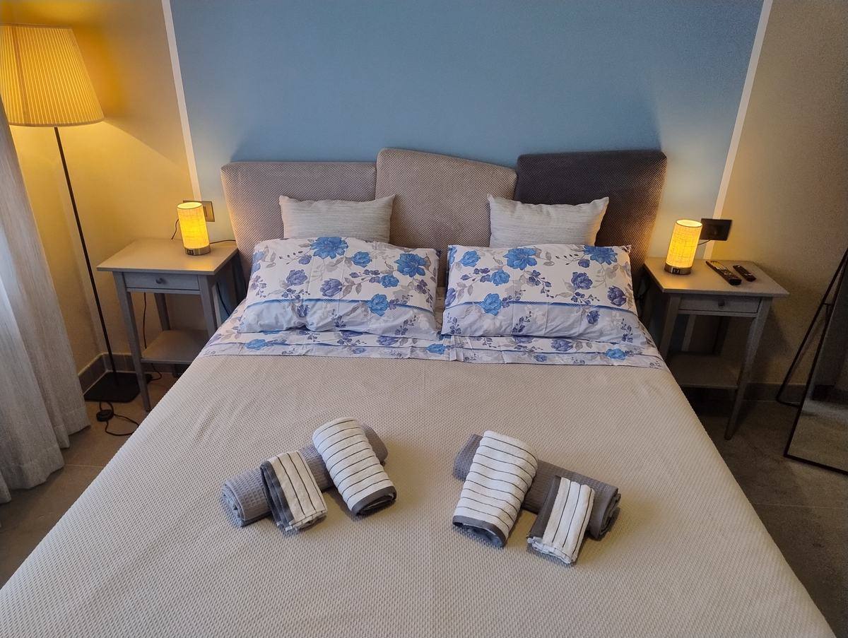 King-size bed with towels and bedside lamps