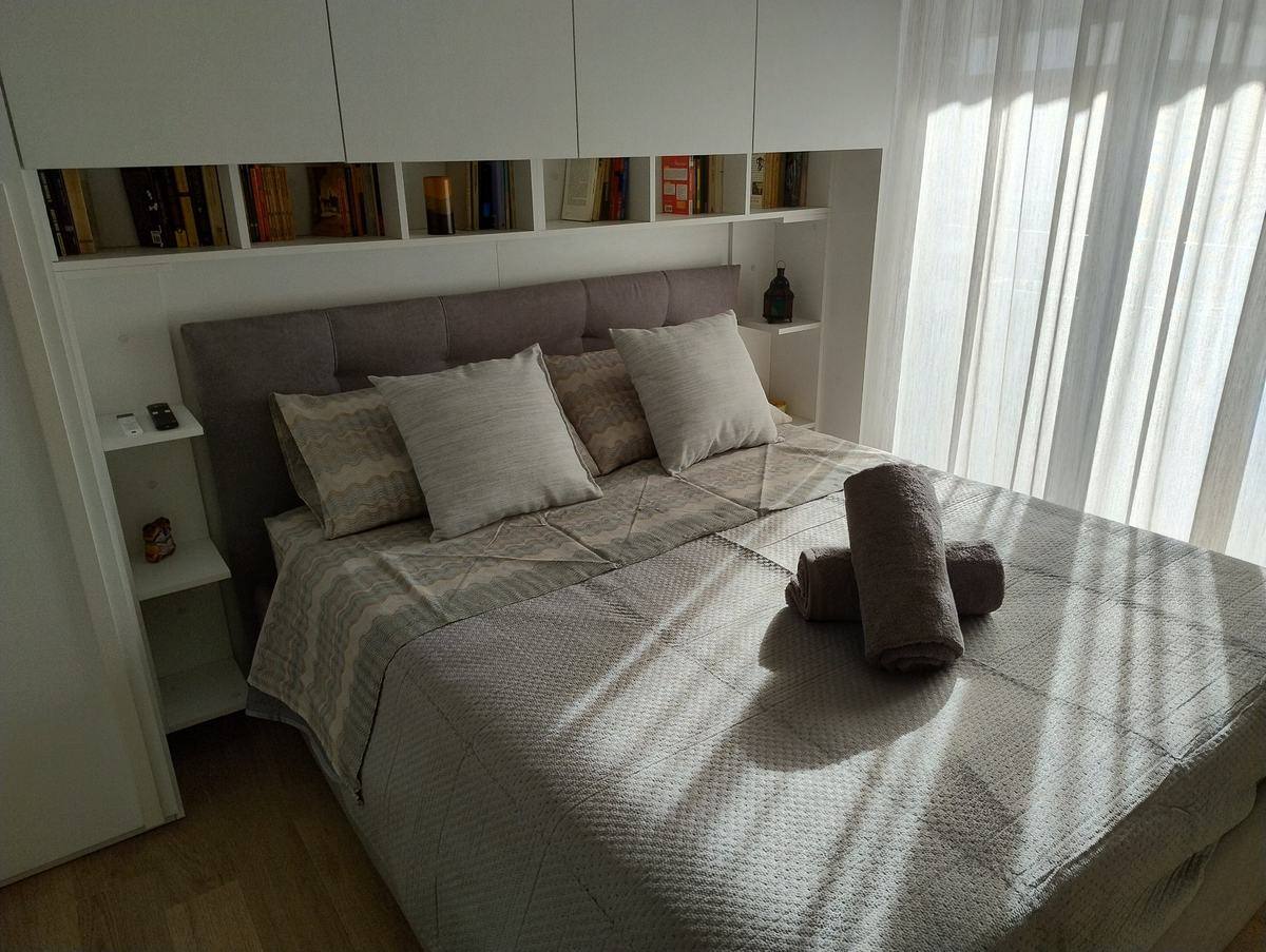 Main bedroom with king-size bed and bookshelves above it