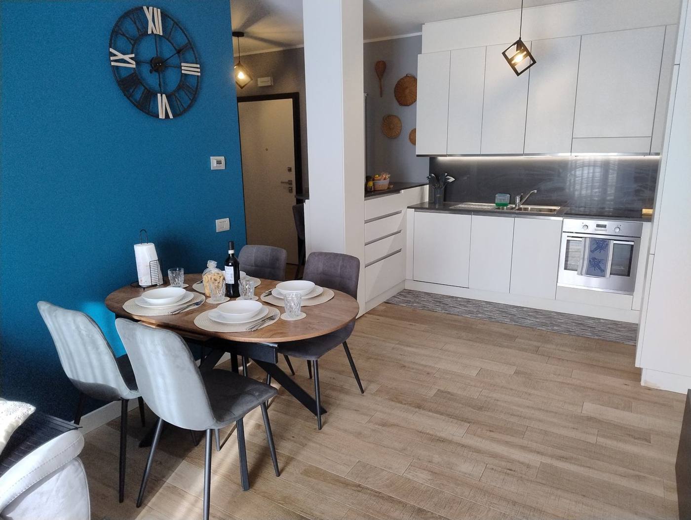 Open-plan living area with round dining table and white kitchen