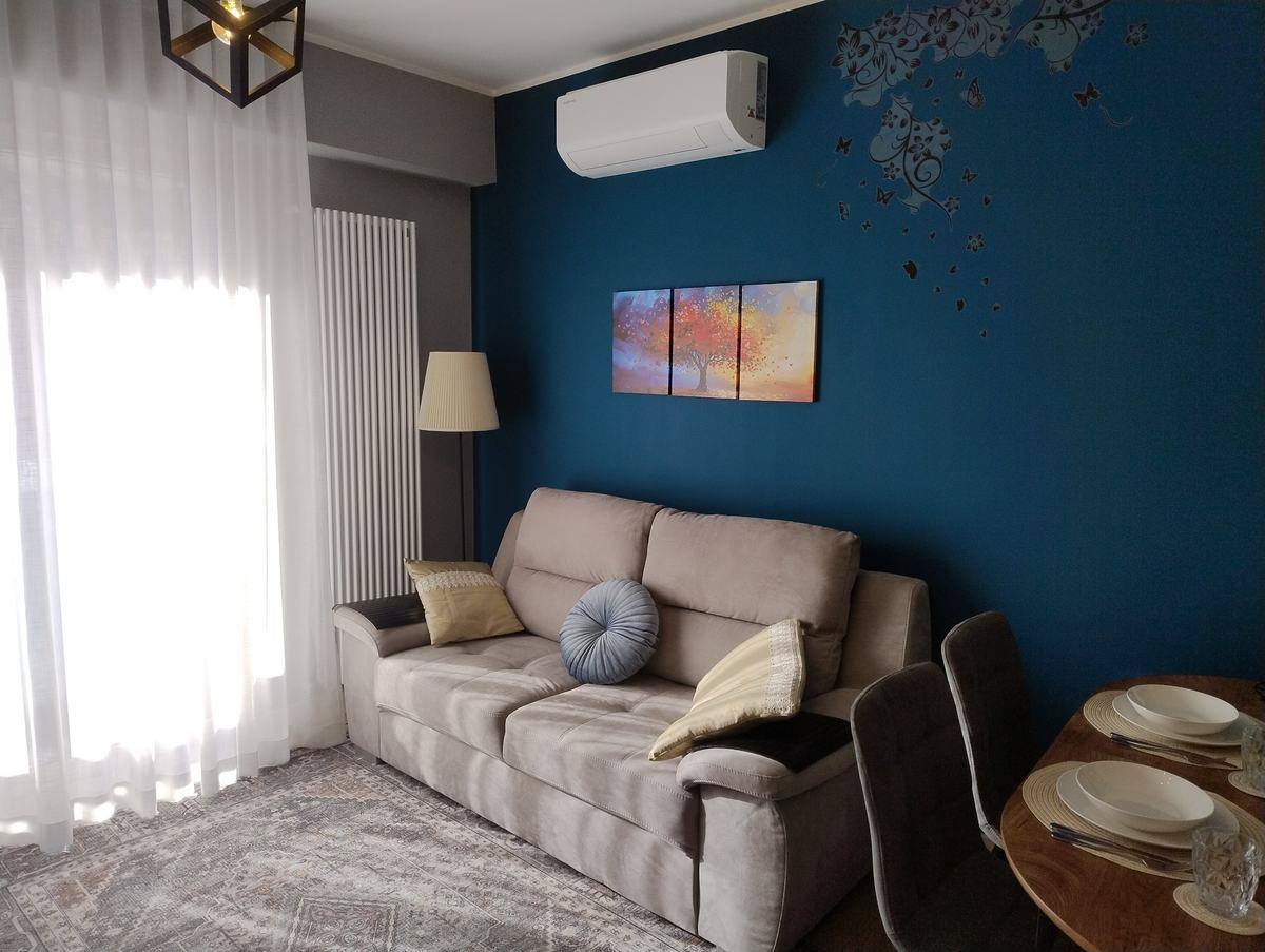 Sofa by the blue feature wall, with air conditioning