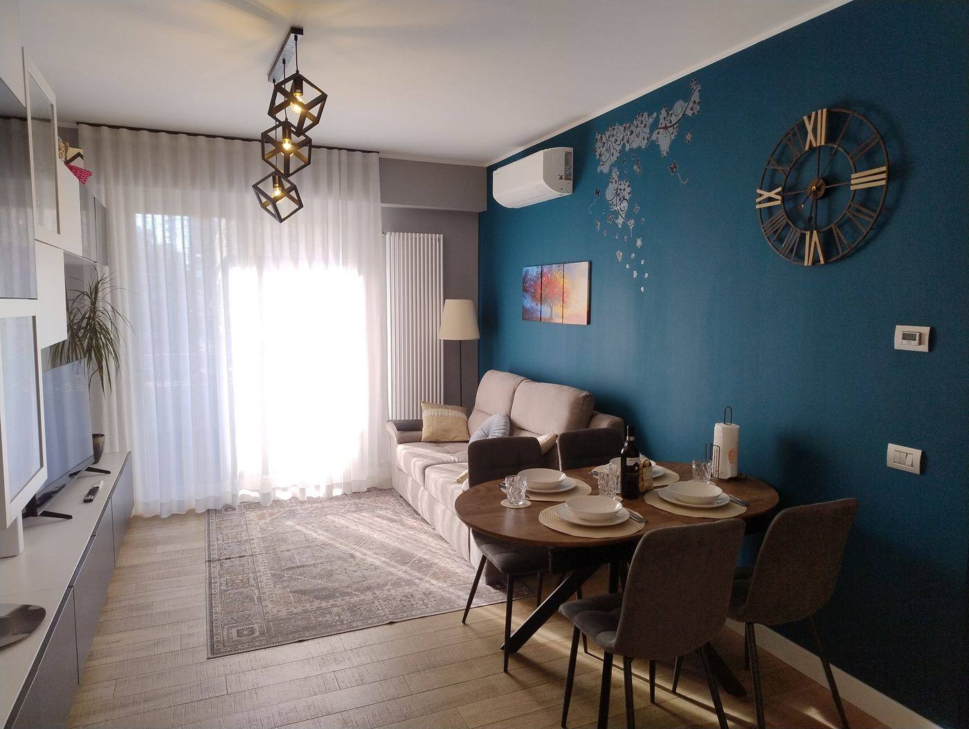 Your Roman Holiday Home, living room with blue wall and set dining table